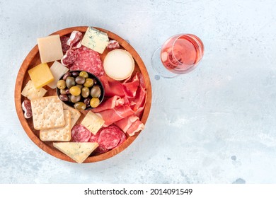 Charcuterie And Cheese Platter, Overhead Shot With Rose Wine. Prosciutto Di Parma Ham, Salami, Blue Cheese, Olives And Crackers, Gourmet Appetizers With A Place For Text