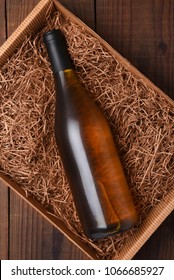 Chardonnay Wine Bottle In Packing Straw: High Angle Shot Of A Single Bottle In A Cardboard Box With Straw Packing.