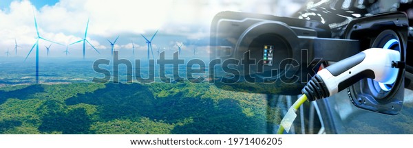Charge EV car vehicle electric battery power\
with blur wind turbine blue sky on panoramic background. The idea\
for nature electric energy technology green eco car environment\
friendly concept.
