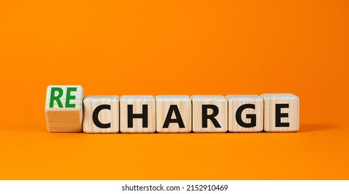 Charge Or Recharge Symbol. Turned Wooden Cubes And Changed The Word Charge To Recharge. Beautiful Orange Table Orange Background. Business Charge Or Recharge Concept. Copy Space.