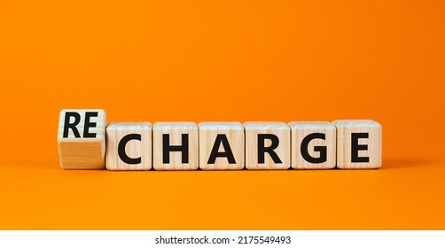 Charge Or Recharge Symbol. Turned Wooden Cubes And Changed The Word Charge To Recharge. Beautiful Orange Table Orange Background. Business Charge Or Recharge Concept. Copy Space.