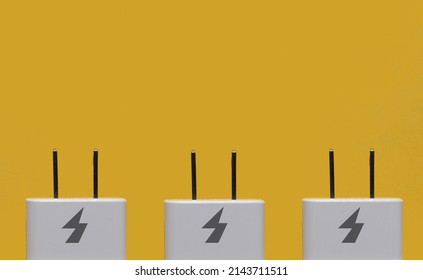 Charger plugs against a yellow background with space for copy - Shutterstock ID 2143711511