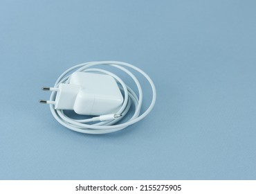 A charger for a tablet on a blue background. Phone charger.