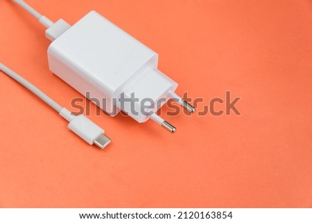 Charger and USB cable type C over red background