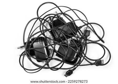 Chargers with tangled wires on a white background. Wired chargers for phones.
