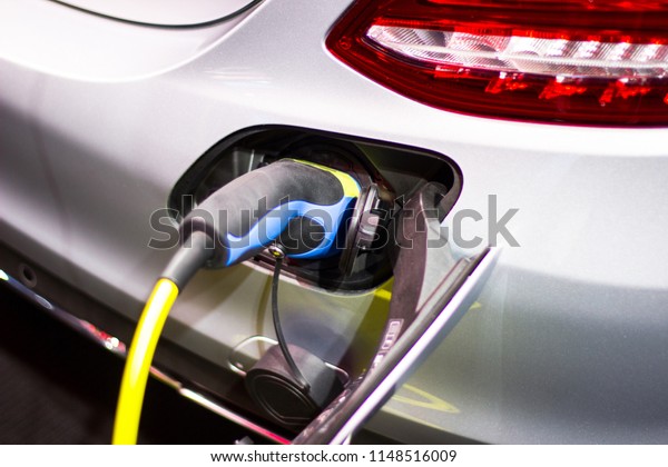 the charging the battery for the car\
new Automotive Innovations the power supply plugged into an\
electric car being charged, concept of energy\
innovation.