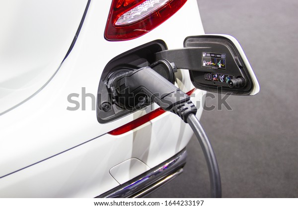 the charging the battery for the car\
new Automotive Innovations the power supply plugged into an\
electric car being charged, concept of energy\
innovation.