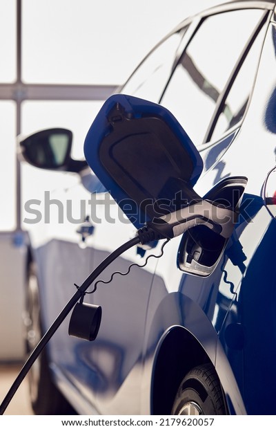 Charging Cable Attached To Environmentally\
Friendly Zero Emission Electric Car In\
Garage