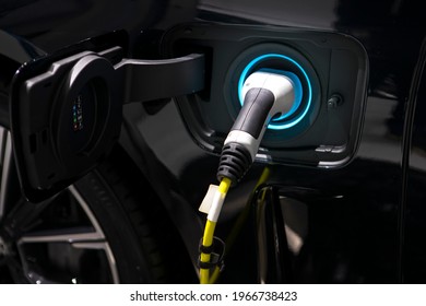 Charging cable plugged into the side of electric car, Car or Electric vehicle, Eco-friendly sustainable energy concept. - Shutterstock ID 1966738423