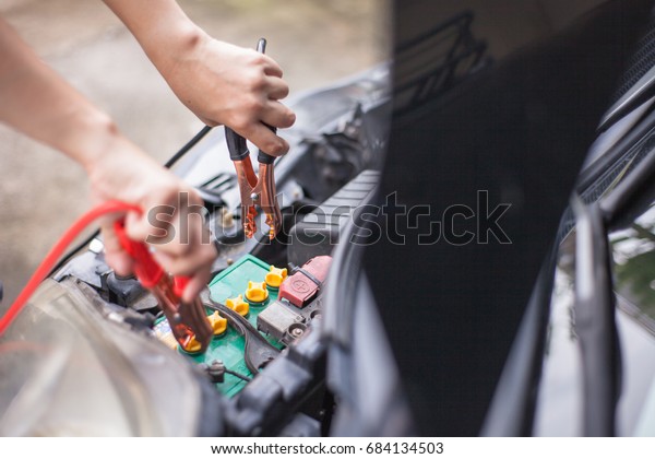 Charging car battery with\
electricity trough jumper cables with copper clamps attached for\
start engine car , An incident when we forget check or\
maintenance\
