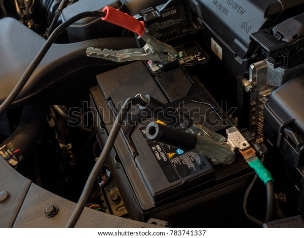 Charging car battery\
with electricity trough jumper cables with copper clamps attached\
for start engine car