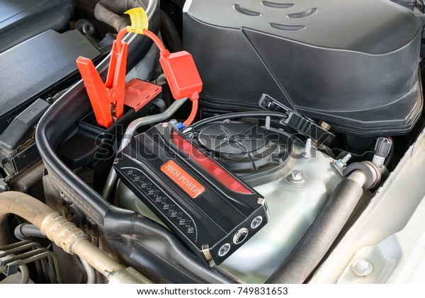 Charging car battery / battery maintenance\
concept : Red and black automotive clip connects to a positive and\
negative pole slot to deliver electric current or transfer energy\
to start motor /\
engine.