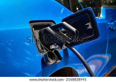 Charging electric automobile with plug at power station