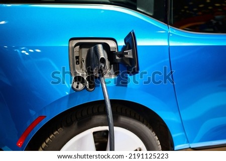 Charging electric automobile with plug at power station