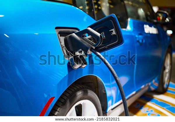 Charging\
electric automobile with plug at power\
station