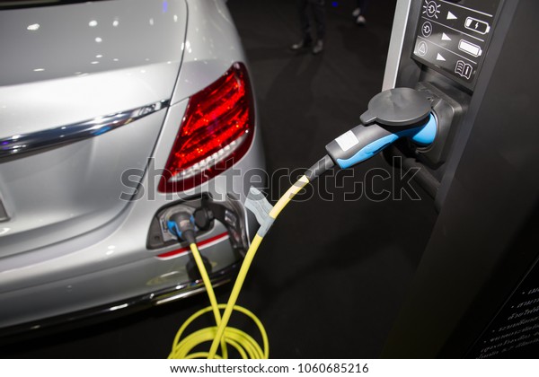 Charging an electric car battery with the power cable\
supply plugged in.