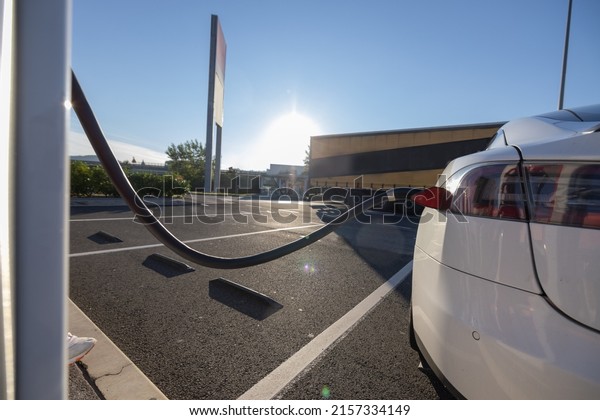 Charging\
an electric car. Modern electric car being charged on a fast\
charger on a motorway rest stop or gas\
station.