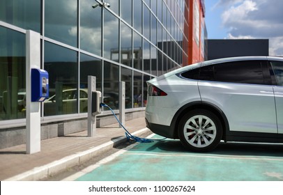 Charging An Electric Car In The Parking Lot With Charge Station