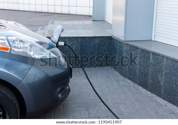 Charging an electric car with the power cable\
supply plugged in. EV Car or Electric car at charging station with\
the power cable supply plugged in. Eco-friendly alternative energy\
concept\
