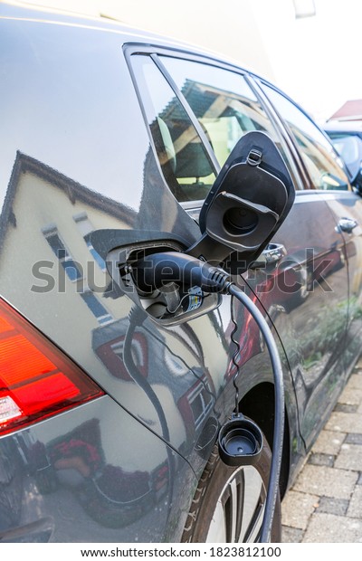 Charging an electric car with the power cable supply\
plugged in.