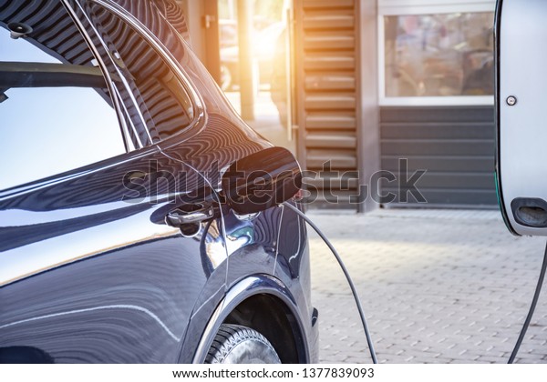 Charging an electric car at a\
car repair shop service garage. Refueling for electric cars\
e-mobility