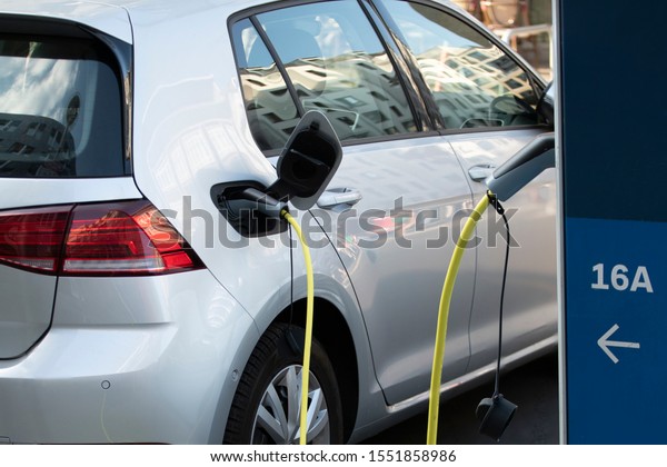 charging the electric car silver color. charging\
station for electric car. Power supply for electric vehicle\
charging. car charging\
cable.