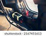 Charging electric power, energy to accumulator or dead battery in breakdown motorcycle for start. Include equipment tool i.e. portable trickle charger, positive negative clamp, red black cable wire.
