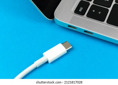 Charging laptop with modern USB Type C port. Laptop low battery concept, technology background, office table top view 