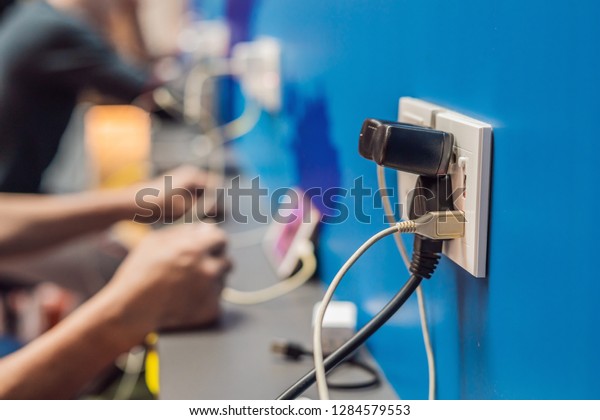 Charging mobile battery station in\
public area. Cellphone plug of electric power adapter in airport\
hall for all passengers. Free charger for devices. Copy\
space