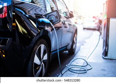 Charging modern electric car on the street which are the future of the Automobile - Shutterstock ID 548313280