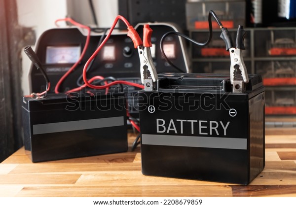Charging motorcycle battery at garage,concept of\
motorcycle maintenance and\
repair.