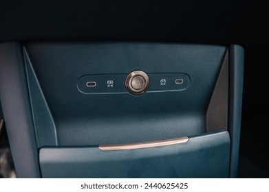 Charging for the phone and type c port in the car and the trunk opening button. Part luxury car inside. Interior of prestige modern electric car. Closeup. Plug phone into car.
