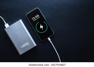 Charging power bank. Portable powerbank with white usb cable for charger mobile phone or smartphone battery. Modern technology concept in top view