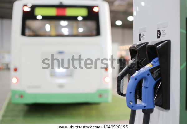 Charging station of an electric car in the background\
of a bus