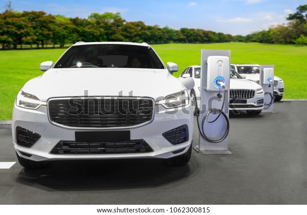 Charging station for\
electric cars clean energy against garden in the future of\
transportation ecology\
concept