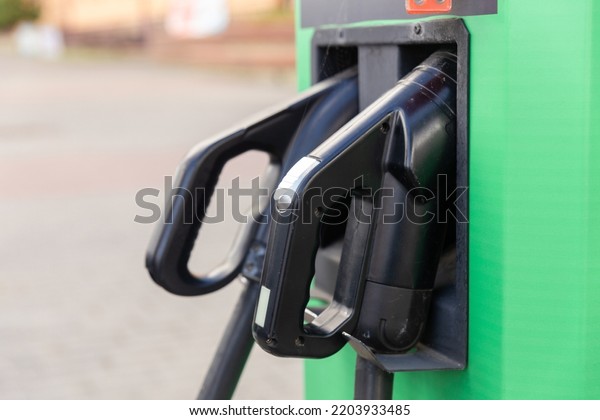 Charging station for electric vehicles with two\
types of cables for connection. Close-up of connectors for\
connecting to the car.