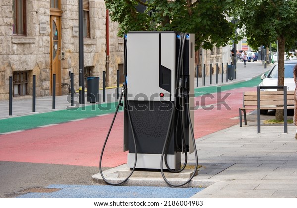 Charging station with two\
sides for electric cars on a sidewalk to recharge two vehicles at\
the same time