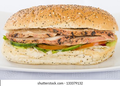 Chargrill Chicken Sandwich - Chargrill chicken breast slices, honey mustard mayonnaise, tomato, cucumber and lettuce in a white bun with sesame seeds.