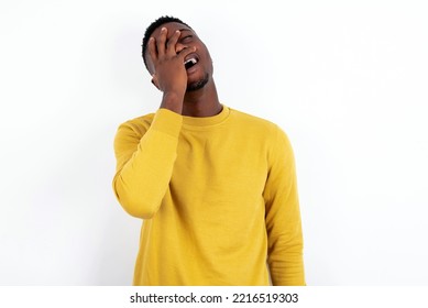 Charismatic Carefree Joyful Young Handsome Man Wearing Yellow Sweater Over White  Background Likes Laugh Out Loud Not Hiding Emotions Giggling Hear Funny Hilarious Joke Chuckling Facepalm.