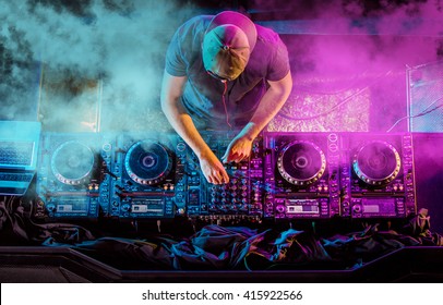 Charismatic disc jockey at the turntable. DJ plays on the best, famous CD players at nightclub during party. EDM, party concept. - Shutterstock ID 415922566