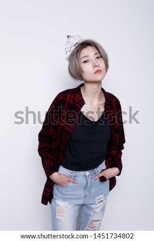 charismatic girl with short hair and a thin figure after a diet. a woman in a crown. street style clothing: men's plaid shirt and blouse with long straps. teenager with healthy skin on his face