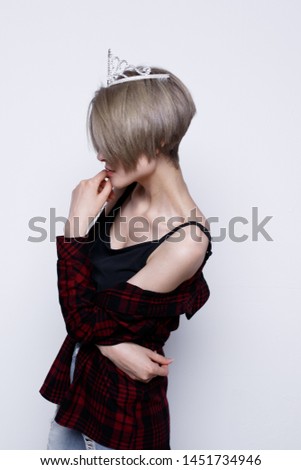 charismatic girl with short hair and a thin figure after a diet. a woman in a crown. street style clothing: men's plaid shirt and blouse with long straps. teenager with healthy skin on his face