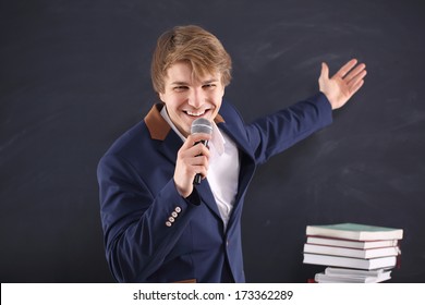 Charismatic Speaker  / Portrait Of A Young, Handsome Man Standing Against The Background Of Blackboard 