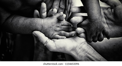 Charity. Close up of diverse people holding hands together. Concept of adopting little children from Africa. Volunteer's programs for helping in poor African counties. Global world problems. Help