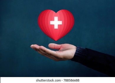 Charity And Donation Concept, Red Heart With Cross Floating Over Opened Hand