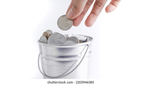 Charity, Donation And Saving Concept - Close Up Of Female Hand Putting Coin Into Silver Bucket