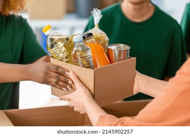 charity, donation and volunteering concept - close up of volunteers giving box of food at distribution or refugee assistance center - Powered by Shutterstock