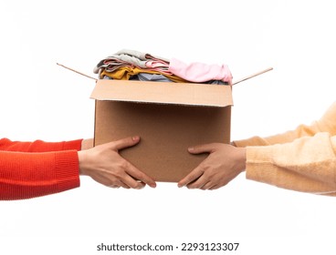 charity, donation and volunteering concept - hands holding cardboard box with clothes isolated on white background - Powered by Shutterstock