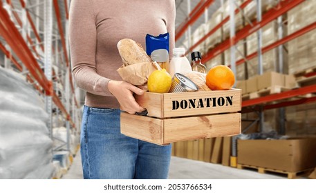 charity, relief work and people concept - close up of woman with food donation in wooden box over warehouse background - Powered by Shutterstock