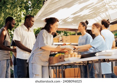 Charity workers helping homeless, refugees and the needy by distributing food outdoors. Hunger relief and assistance are provided to people in poverty through nonprofit organization.